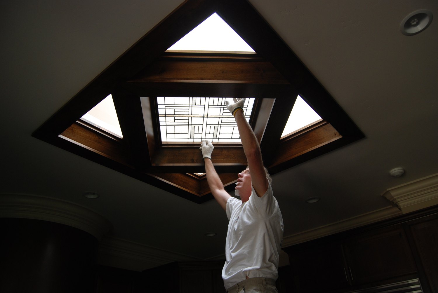 Keith S. Bramer holding a leaded panel beneath an installed skylight