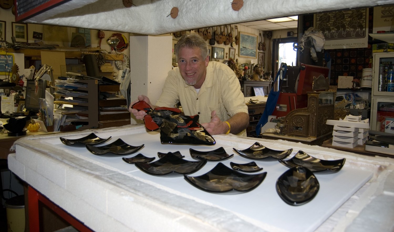 Keith S. Bramer in the studio with a run of fused glass dishes